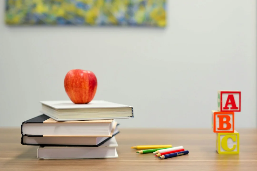 Books, an apple and alphabet blocks on a table